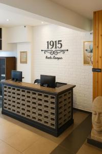 a reception desk in a lobby with a head on the wall at Hotel 1915 Chinatown Kuala Lumpur in Kuala Lumpur