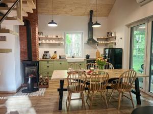 a kitchen with a table and chairs and a fireplace at Leśne Anioły in Czarna