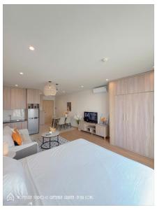 a living room with a white bed and a kitchen at By's House- Căn hộ View biển Hạ Long in Ha Long