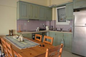 a kitchen with a wooden table and a refrigerator at Effie's Vacation House in Kanali