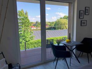 a room with a sliding glass door with a table and chairs at LigetResidence Apartman in Fonyód