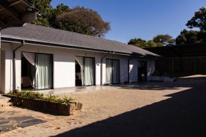 内尔斯普雷特Mandulia Guest House的一栋侧面有窗户的白色建筑