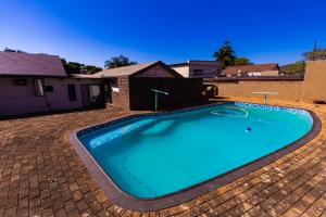 内尔斯普雷特Mandulia Guest House的砖院里的一个大型蓝色游泳池