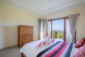 une chambre avec un lit et une grande fenêtre dans l'établissement Atuh Galaxy Cottage, à Nusa Penida