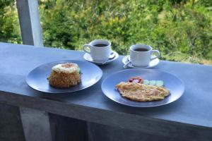 deux assiettes de nourriture et deux tasses de café sur une table dans l'établissement Atuh Galaxy Cottage, à Nusa Penida 21 autres photos