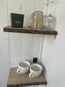 a shelf with two bowls and glasses on it at idyllisk hytte ved vannet in Skien +4 photos