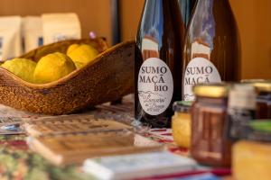 a table with two bottles of wine and a basket of lemons at Casa Fermil do Lago in Veade