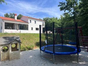a playground with a trampoline and a dog house at Vila Prisunca jacuzzi & swimming pool in Pazin