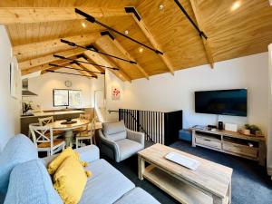 a living room with a blue couch and a table at Walk to Queenstown City, 30mins to Ski, Free Parking & Wifi, Gym in Queenstown