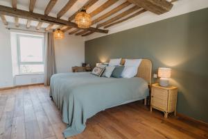 a bedroom with a large bed and a window at Le Clos d'Omaha - Suites luxueuses à 5 min d'Omaha Beach in Englesqueville-la-Percée