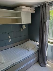 a small bed in a room with a window at Camping DEL MAR in Argelès-sur-Mer