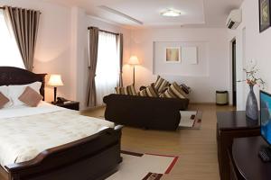 a bedroom with a bed and a desk and chairs at Chau Pho Hotel in Chau Doc
