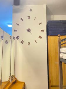 a clock on a wall next to a bed at Mesatierra, Davao - Condo in Davao City