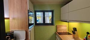 a kitchen with green and yellow walls and a window at Ferienwohnung Sächsische Schweiz Kurort Rathen in Kurort Rathen