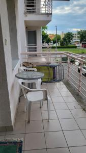 a balcony with a table and chairs on a building at Casablanca Apartman in Hajdúszoboszló +8 photos