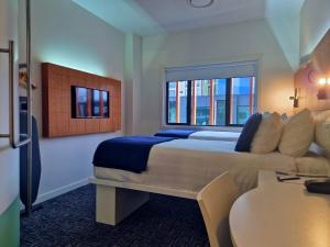 基督城BreakFree on Cashel, an Accor Hotel的一间带床和桌子的酒店房间