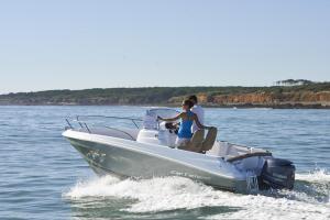 two people in a speed boat on the water at barca maria in Ladispoli