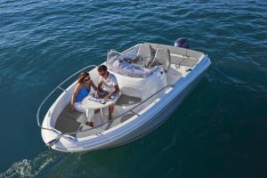 a man and woman sitting on a boat in the water at barca maria in Ladispoli