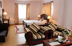 a living room with a couch and a bed at Chau Pho Hotel in Chau Doc