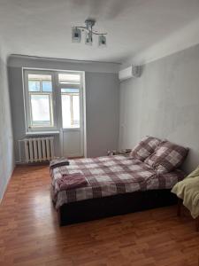 a bedroom with a bed with a plaid blanket at Aeroport apartament in Chişinău