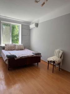 a bedroom with a bed and a chair in it at Aeroport apartament in Chişinău