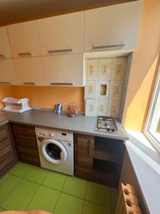 a kitchen with a stove and a washing machine at Aeroport apartament in Chişinău