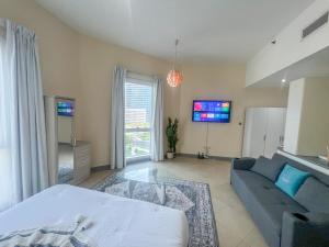 una sala de estar con una cama y un sofá en Snug Studio With City Views, Perfect For Couples, en Dubái