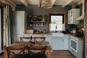 a kitchen with a table and chairs and a kitchen with green walls at Mech i brzoza in Baligród