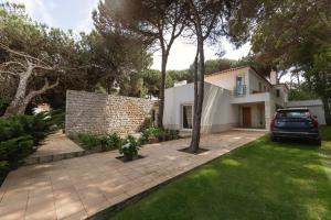 une maison avec une voiture garée dans la cour dans l'établissement Oasis Pool Villa - Praia D'El Rey Golf Resort, à Palaios