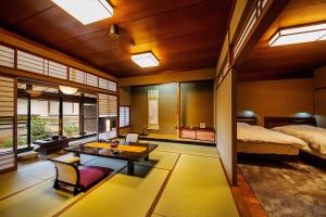a bedroom with a bed and a table in a room at Ryoutei Ryokan Yasui in Hikone