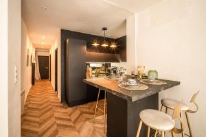 a kitchen with a counter and stools in a room at L'Appart Central - Chic et Confort in Narbonne +3 photos