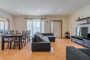 ein Wohnzimmer mit einem Sofa und einem Tisch sowie ein Esszimmer in der Unterkunft Casal do Porto - Um refugio de férias in Vila Verde