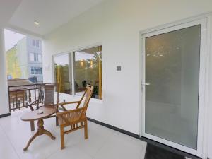 a room with a chair and a table on a balcony at Neo Bay Hotel in Weligama
