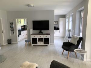 a living room with a flat screen tv on a white cabinet at Landhaus Scholz in Dollerup +29 photos