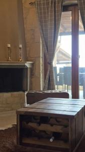 a wooden coffee table in a living room with a television at To Petrino, Stylish Stone House, Elani in Siviri