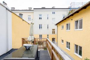 a balcony with a table and an umbrella at Ignaz 28 Apartment#5 in Salzburg