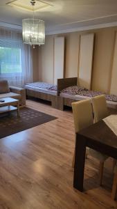 a room with two beds and a table and chairs at Casablanca Apartman in Hajdúszoboszló