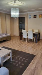 a living room with a dining table and white chairs at Casablanca Apartman in Hajdúszoboszló