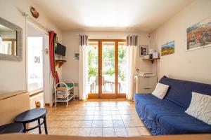 a living room with a blue couch and a table at Le Mazet des Criques Charm and Beach 2 Steps Away in Cavalaire-sur-Mer