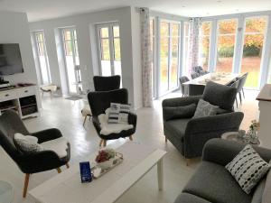 een woonkamer met banken en stoelen en een tafel bij Landhaus Scholz in Dollerup