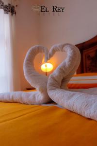 two towels in the shape of a heart on a bed at El Rey in Taxco de Alarcón