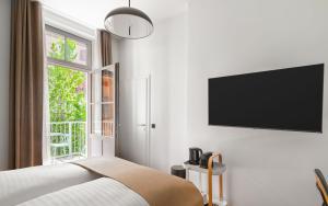 a bedroom with a bed and a television on a wall at Limehome Graz Trauttmansdorffgasse in Graz