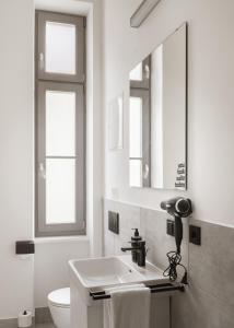 a bathroom with a sink and a toilet and a mirror at Limehome Graz Trauttmansdorffgasse in Graz +51 photos