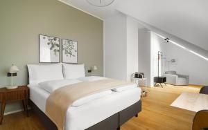 a white bedroom with a large bed and a staircase at Limehome Graz Trauttmansdorffgasse in Graz