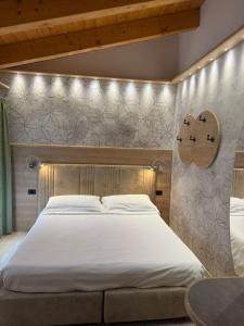 ein Schlafzimmer mit einem großen Bett mit Lampen an der Wand in der Unterkunft Hotel Villa Fosine in Pinzolo