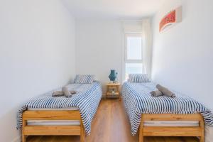 Habitación con 2 camas, paredes blancas y suelo de madera. en Seaview Apartment in Canet with Rooftop Pool, en Canet de Berenguer 45 fotos más