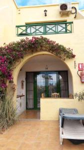 an entrance to a building with an arch with flowers at Castillo Mar in Caleta De Fuste