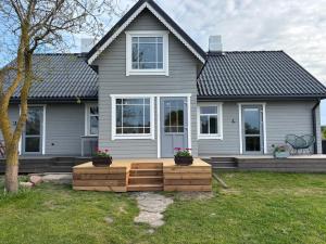 a house with a wooden deck in front of it at Pie Jūras Pāvilostā in Pāvilosta
