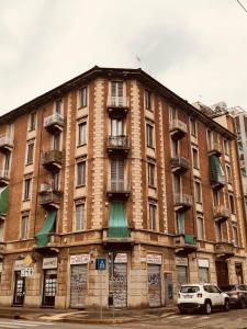 un grande edificio in mattoni con macchine parcheggiate di fronte di Casa Torino Lingotto, fiere, metro, Inalpi Arena,Centro Congressi, Ospedale, Politecnico a Torino