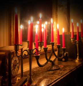 a group of red candles on a table with a clock at Love Room LE DONJON BDSM in Bolbec